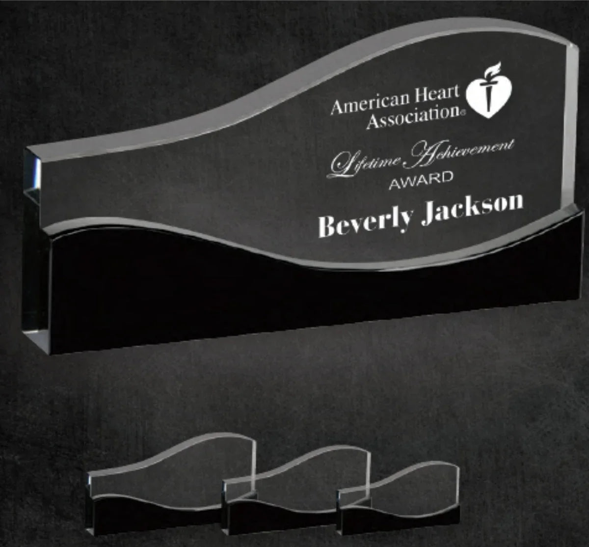 AwardsHere Vista Crystal Award, clear wavy design with black base, engraved. Displays different sizes, suitable for achievement awards.